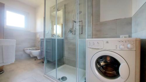 a bathroom with a washing machine and a shower at PANORAMIC apartment in Bardolino