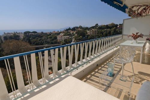 Elle comprend un balcon doté d'une balustrade blanche, d'une table et de chaises. dans l'établissement CANNES Vue Mer, à Cannes