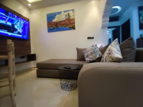sala de estar con sofá y TV de pantalla plana en Pedro Appartement, en Essaouira