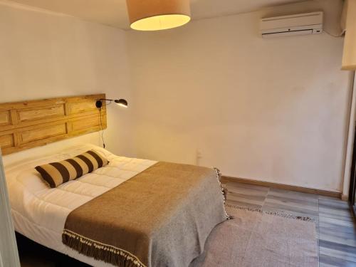 1 dormitorio con 1 cama en una habitación con lámpara en Casa Carrasco, en Montevideo