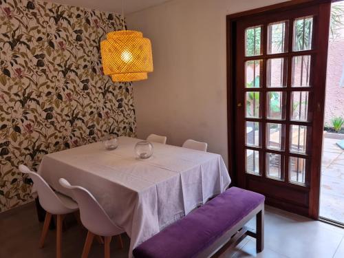 a dining room with a table and chairs and a lamp at Casa Carrasco in Montevideo