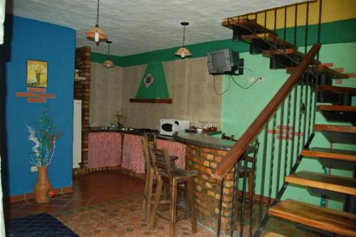 a living room with a staircase and a bar with a table at Cabañas Falconia in Mérida
