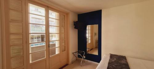 um quarto com uma cama, uma janela e uma porta em Copacabana Blue Hotel no Rio de Janeiro
