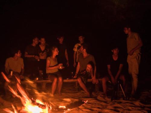 a group of people sitting around a fire at Naks Shack in Koh Ta kiev Island