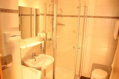 a white bathroom with a shower and a sink at Ferienwohnung-Schwarzwald-in-der-Pension-Gloecklehof in Todtnau