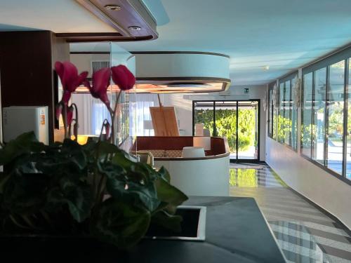 a kitchen with a table with red flowers on it at Arthotel Gabbiano Azzurro Due in Marciana Marina