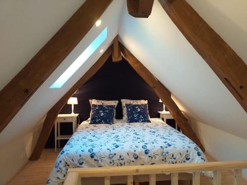 ein Schlafzimmer mit einem Bett im Dachgeschoss in der Unterkunft Domaine d'Antigneul in Bours