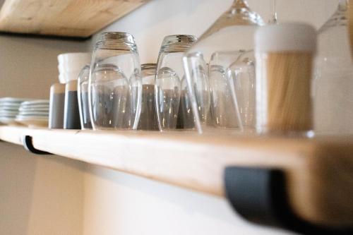 a group of wine glasses on a wooden shelf at Avodation in Walvis Bay