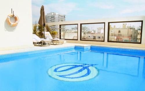 a large swimming pool with blue water in a building at Argenta Tower Hotel & Suites in Buenos Aires