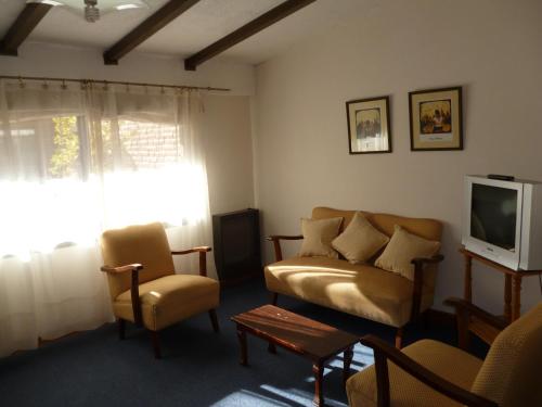 un salon avec un canapé et une télévision dans l'établissement Hosteria Pastoral & Spa, à La Cumbre