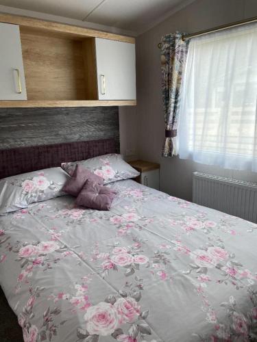 a bedroom with a bed with pink flowers on it at Swift Bordeaux in Dunoon