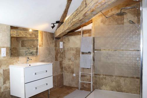 ein Bad mit einer Dusche und einem Waschbecken in der Unterkunft La Cabane in Penne-dʼAgenais