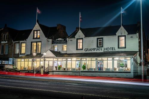 a building with a sign on the front of it at night at Grampian Hotel in Perth