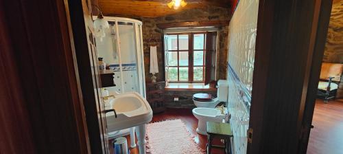 ein Bad mit einem Waschbecken und einem WC in der Unterkunft Viña Cazoga in Sober