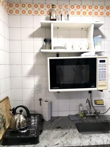 a microwave above a stove in a kitchen at Monoambiente Centro in Cordoba