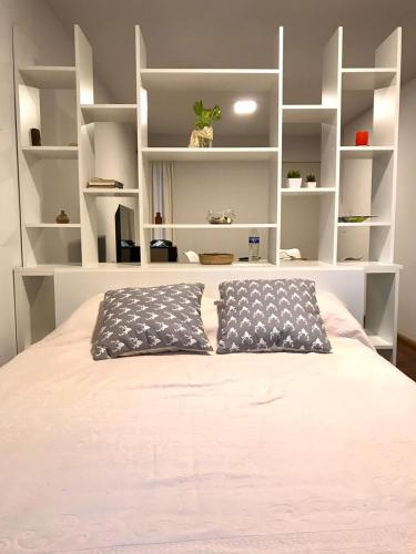 a bedroom with a bed with white shelves at Monoambiente Centro in Cordoba