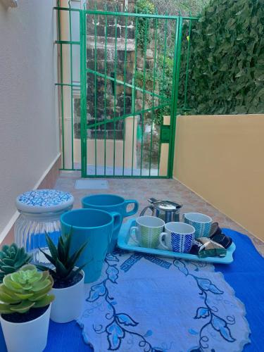 a table with blue cups and potted plants on it at Villa Maria - Family House in Monte di Procida