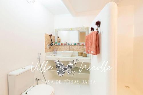 a bathroom with a sink and a toilet and a mirror at Villa Nicolle - Bahia - Praia do Espelho in Praia do Espelho
