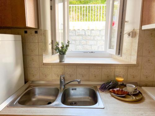 encimera de cocina con fregadero y ventana en Holiday Home Adriatic Pearl, en Dubrovnik