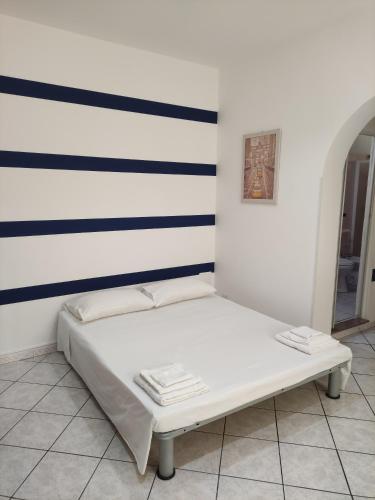 uma cama num quarto com uma parede listrada em Ponente em Donnalucata