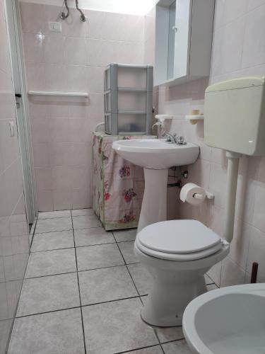 uma casa de banho com um WC branco e um lavatório. em Ponente em Donnalucata