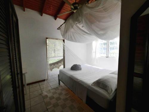 a bedroom with a bed with a cat sitting on it at VILLA COLIBRI in Mon Repos