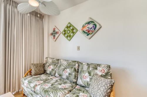 a living room with a couch and pictures on the wall at Ilikai 883 in Honolulu