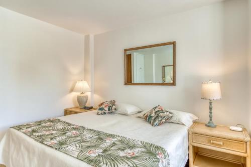 a white bedroom with a bed and a mirror at Ilikai 883 in Honolulu