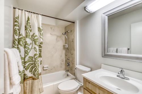 a bathroom with a sink toilet and a mirror at Ilikai 883 in Honolulu