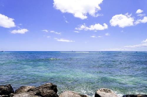 a view of the ocean with rocks in the water at Ilikai 883 in Honolulu