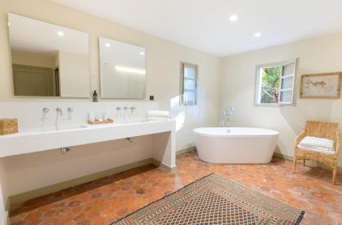 a large bathroom with a tub and a sink at Les Villas du Château de Berne in Lorgues