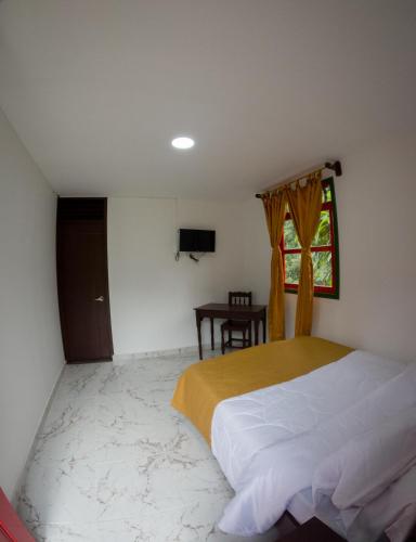 a bedroom with a bed and a window and a table at El Edén hotel Campestre in Pensilvania