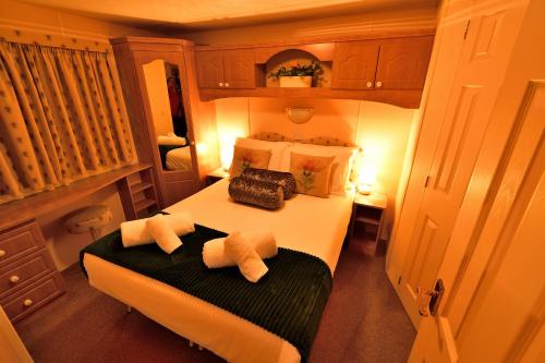1 dormitorio con 1 cama grande y 2 toallas en 57 Peaceful Corner Caravan, en Balminnoch