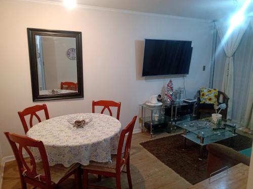 a dining room with a table and a mirror at Viña del mar descanso y entretención in Viña del Mar