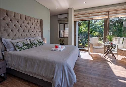 a bedroom with a large bed and a large window at Ekuthuleni Modern Christian Guesthouse with seaview in Umhlanga Ridge