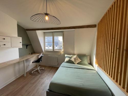 - une petite chambre avec un lit et un bureau dans l'établissement Studio Anchin, à Douai