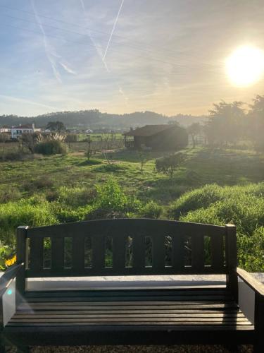 a bench sitting on top of a field with the sunset at Quinta Cunte - Casa Girassol in São Luis