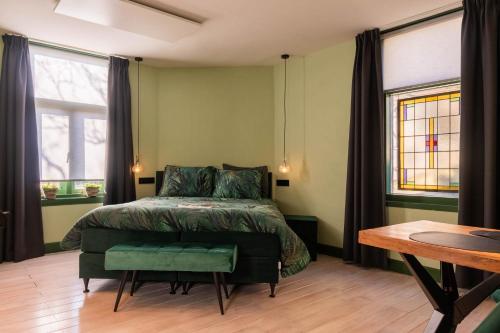 a bedroom with a bed and a table and windows at Luxe en ruim vakantiehuis voor 4 personen. in Nieuw-Lekkerland