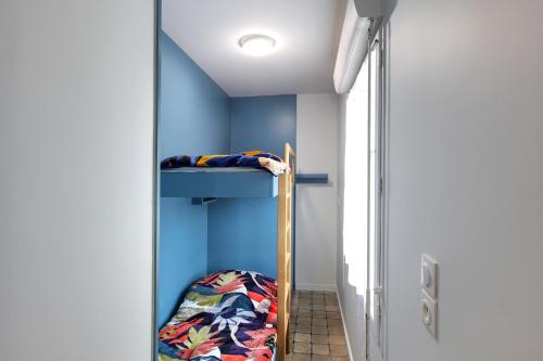 Etagenbett in einem Zimmer mit blauer Wand in der Unterkunft Superbe appartement 4 personnes Arcachon Abatilles avec parking 500m plage Péreire in Arcachon