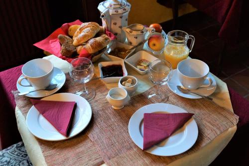 a table with plates of food and glasses of orange juice at Moulin de Belle Isle in Bèze