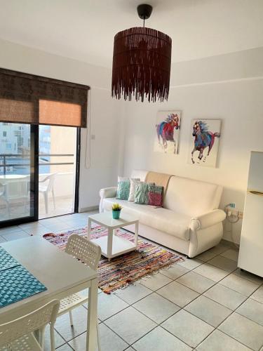 a living room with a couch and a table at Krasas Beach Apartments in Larnaca
