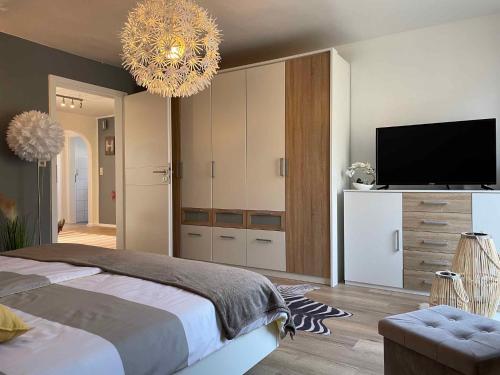 um quarto com uma cama, uma televisão e um lustre em Apartment in Schauenstein - Franken 40833 em Schauenstein