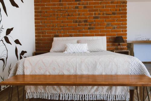 a bedroom with a bed and a brick wall at Palta 60 Valle de Guadalupe in Valle de Guadalupe