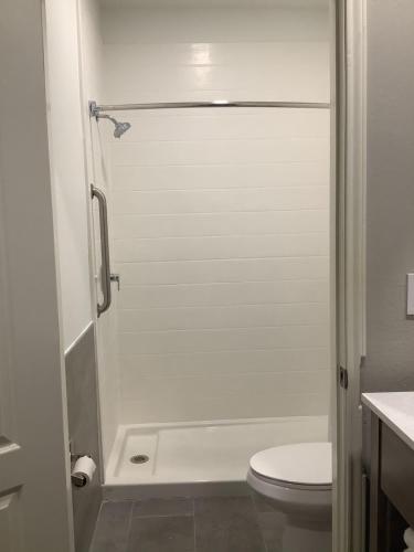 a white shower in a bathroom with a toilet at Americas Best Value Inn & Suites San Benito in San Benito