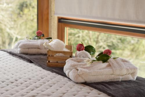 a row of towels on a bed with a window at O MIRADOR da RÍA in Outes