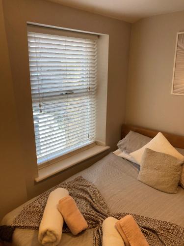 a bedroom with a bed and a window with towels on it at 'Bloomfield' at stayBOOM in Lancaster