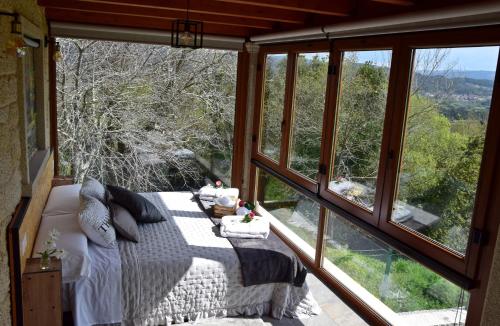 a bedroom with a bed in a room with windows at O MIRADOR da RÍA in Outes