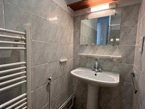 a bathroom with a sink and a mirror at Au coeur de Cauterets, T2 + alcôve. 4P. in Cauterets