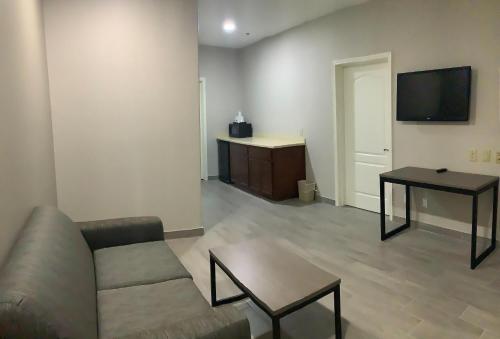 a living room with a couch and a table and a television at Americas Best Value Inn & Suites San Benito in San Benito