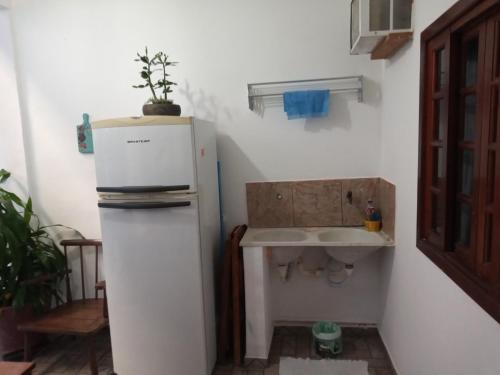 uma pequena cozinha com um frigorífico e um lavatório em Suíte Cleo em Cabo Frio